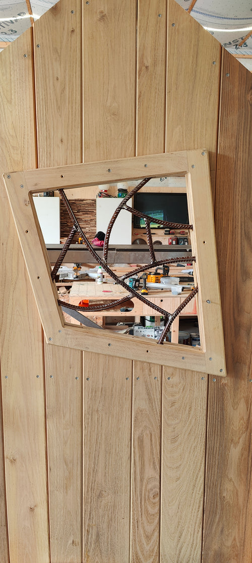 Wooden framed mirror on a wooden wall